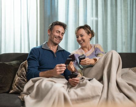 Ein Mann und eine Frau liegen auf einer Liege und spielen Karten