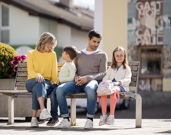 Eine Familie mit zwei Kindern spaziert durch Natz