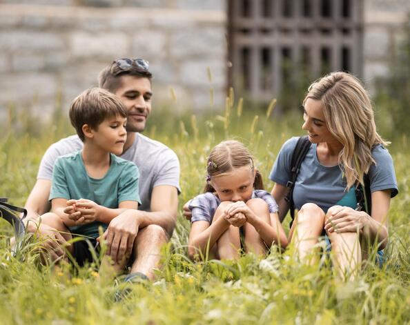 Una famiglia è seduta in un prato