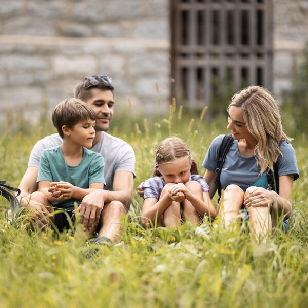 Eine Familie sitzt in einer Wiese