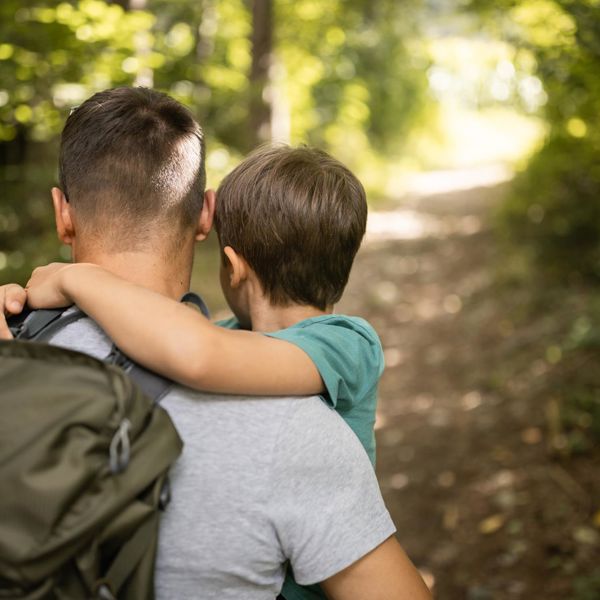Ein Mann und ein Kind wandern im Wald