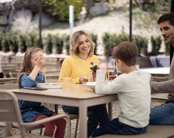Una famiglia con due bambini mangia piatti tipici altoatesini