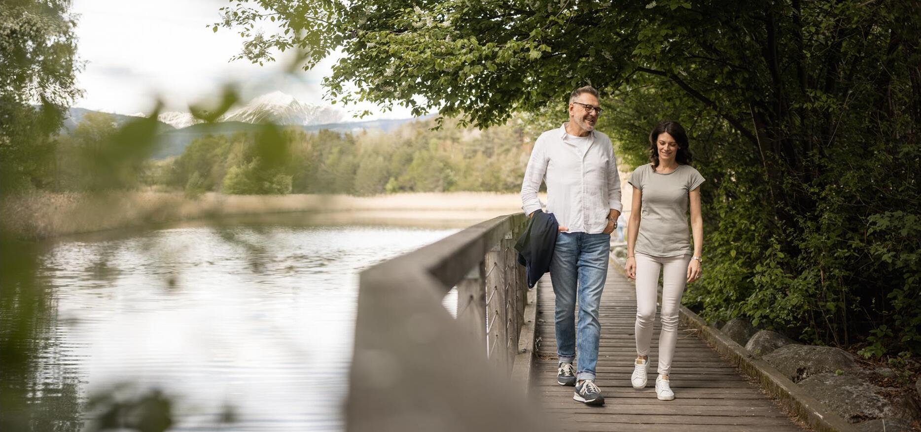 Ein Mann und eine Frau spazieren den Apfelweg entlang