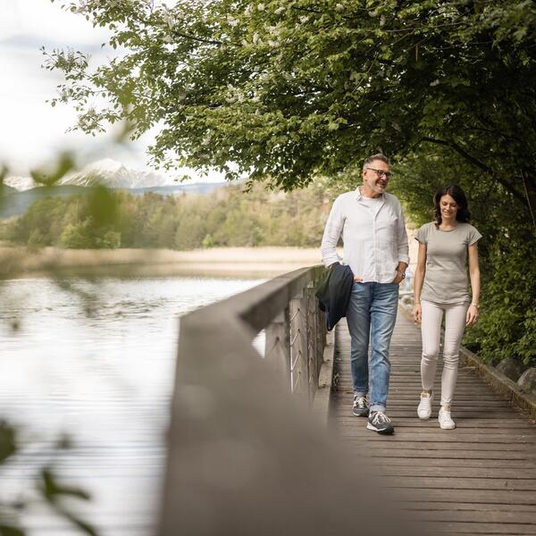 Ein Mann und eine Frau spazieren den Apfelweg entlang