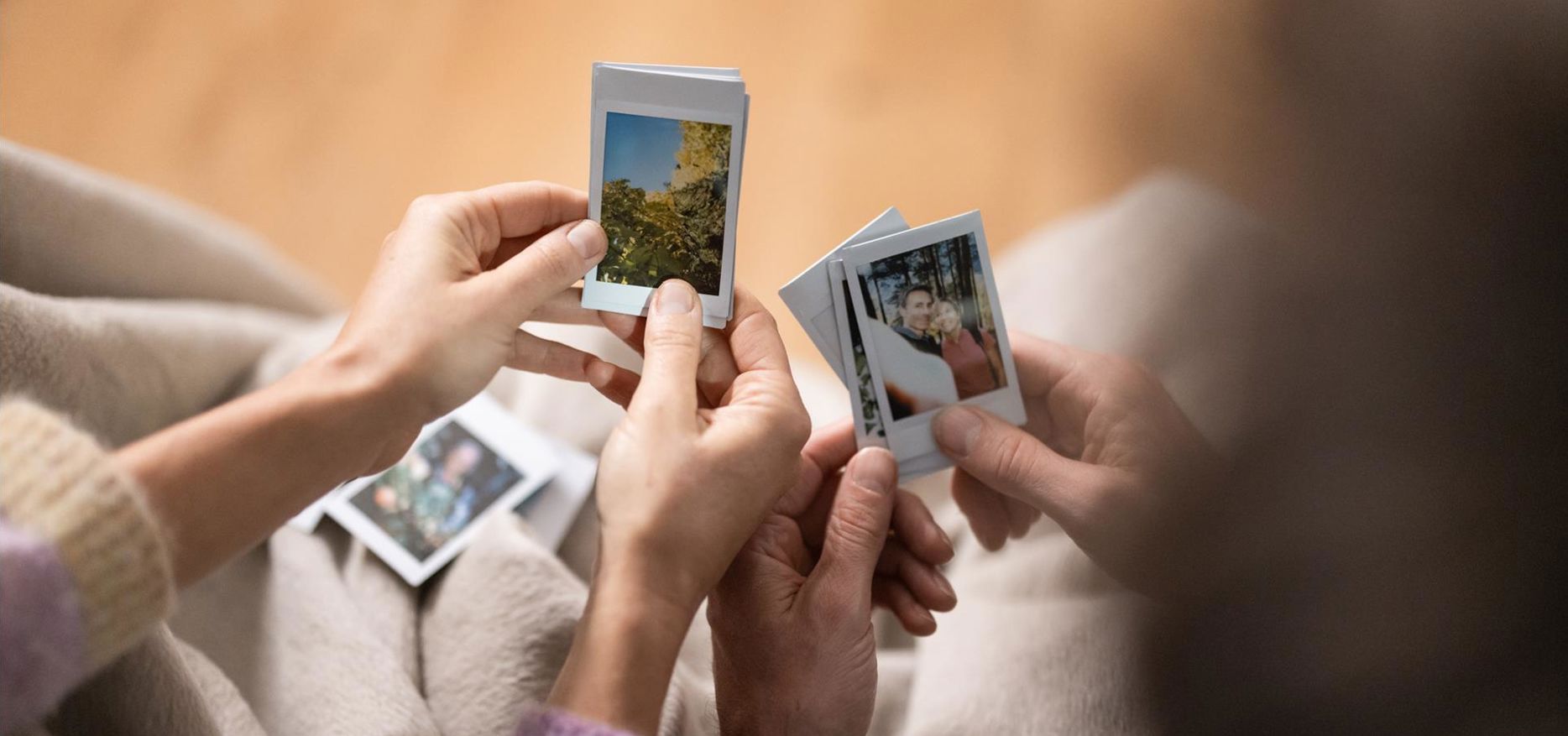 Zwei Personen schauen sich Polaroid Fotos an