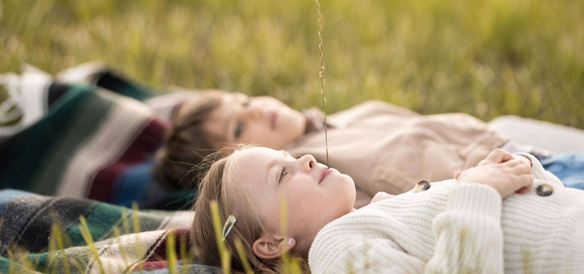 Zwei Kinder liegen im Gras