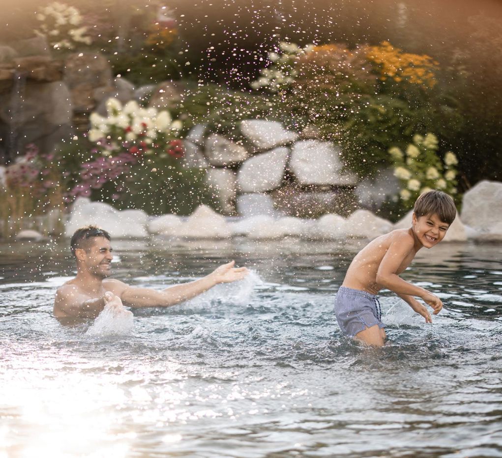 A man and a child are playing in the water