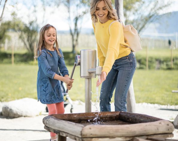 Eine Frau spielt mit einem Kind auf dem Spielplatz Apfelgarten
