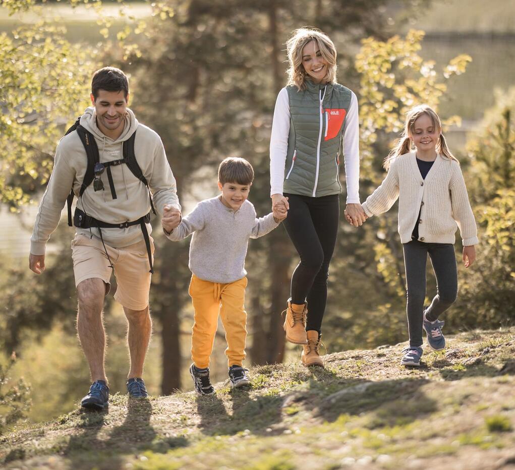 Eine Familie mit zwei Kindern spaziert den Apfelweg entlang