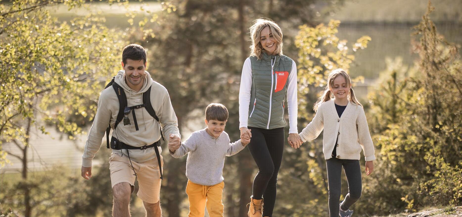 Eine Familie mit zwei Kindern spaziert den Apfelweg entlang