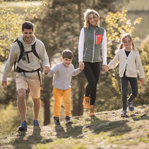 Una famiglia con due bambini passeggia lungo il sentiero delle mele