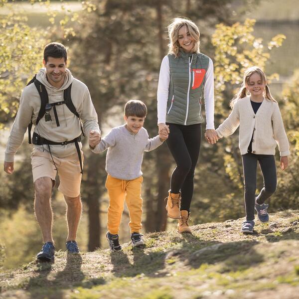 Eine Familie mit zwei Kindern spaziert den Apfelweg entlang