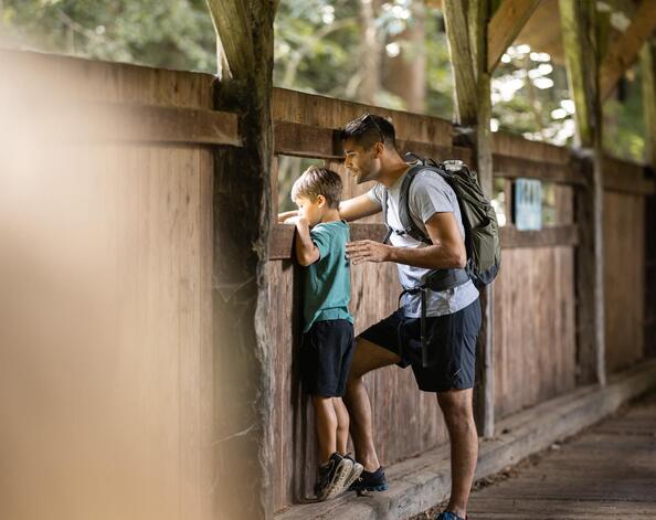 Un uomo e un bambino guardano da un ponte