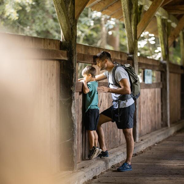 Un uomo e un bambino guardano da un ponte
