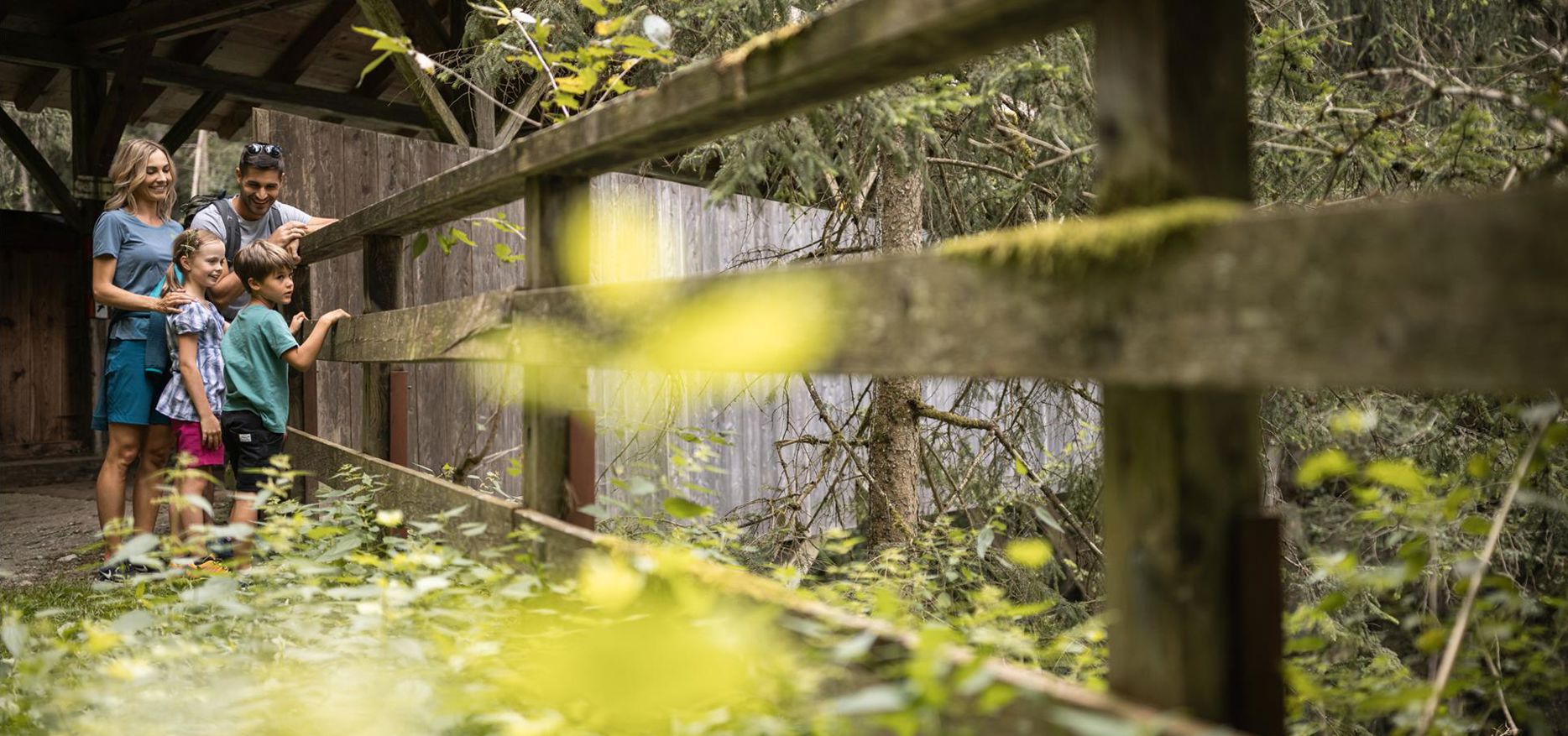 A family is standing on a bridge