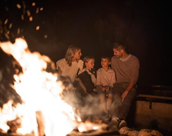 Una famiglia siede davanti a un falò