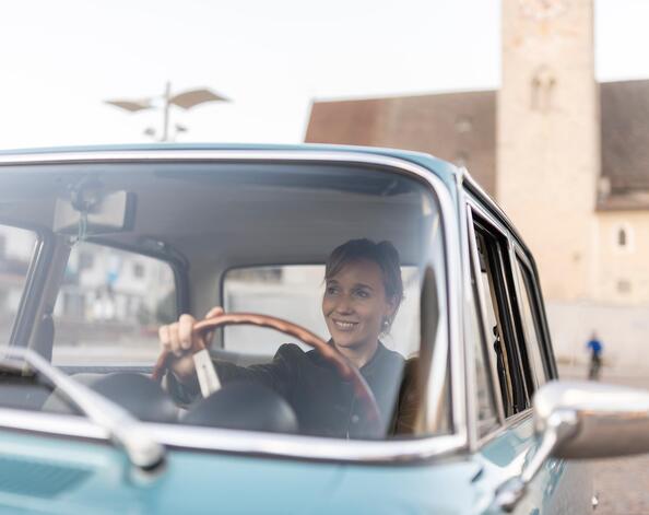 Eine Frau sitzt in einem Oldtimer