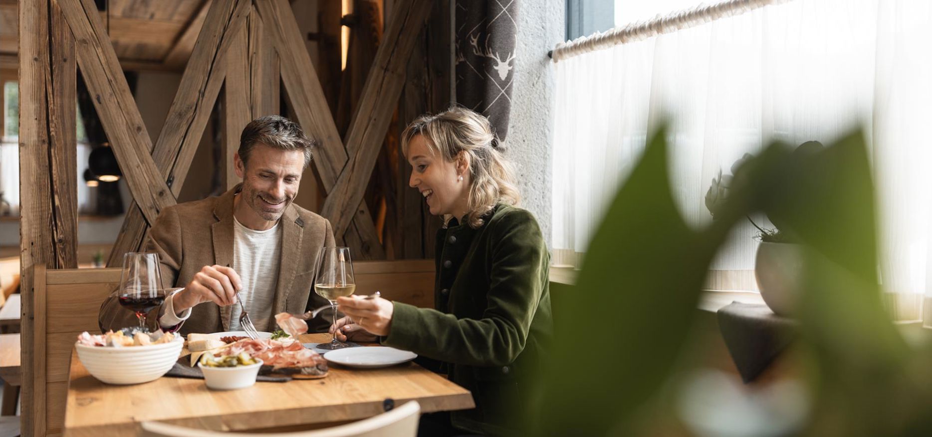 Ein Mann und eine Frau sitzen an einem Tisch und essen typische Südtiroler Gerichte