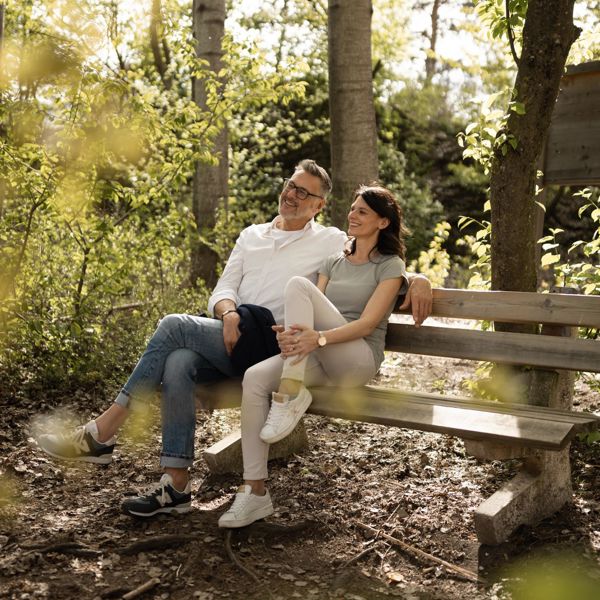 A man and a woman take a break in the forest