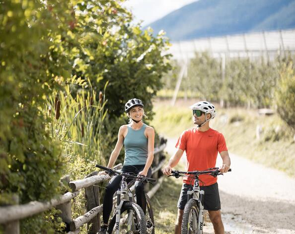 A man and a woman are riding a bike