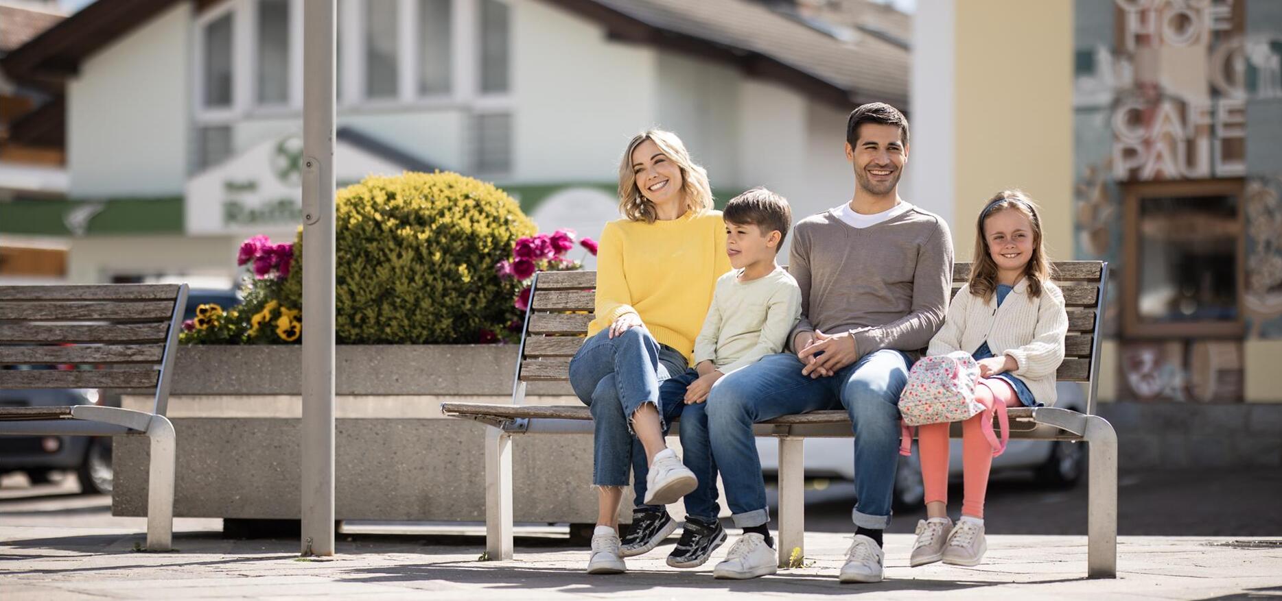 Eine Familie mit zwei Kindern spaziert durch Natz