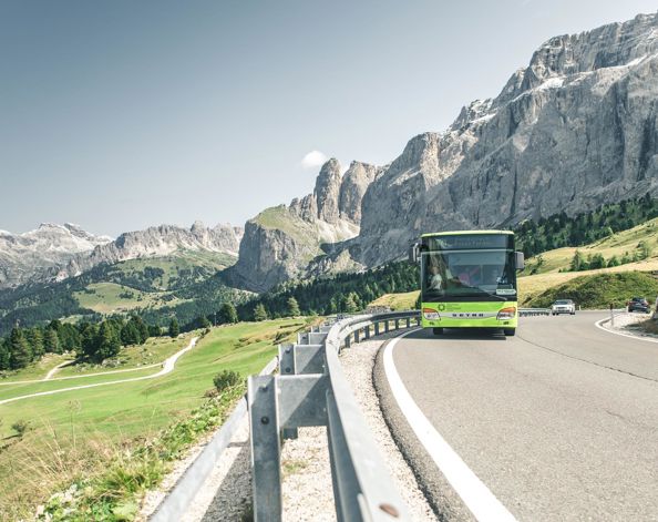 A bus is driving along a mountain pass road