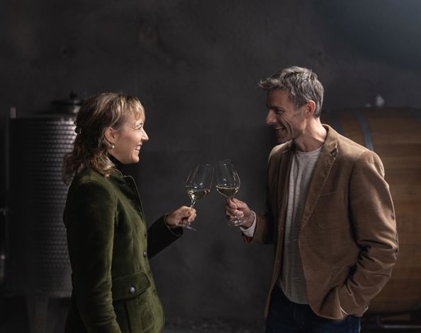 Ein Mann und eine Frau stoßen mit einem Glas Wein an