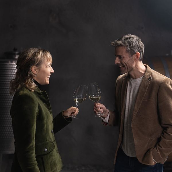 Ein Mann und eine Frau stoßen mit einem Glas Wein an