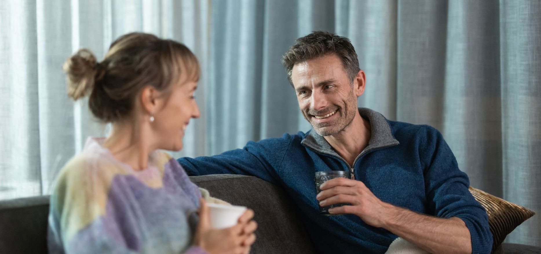 Un uomo e una donna bevono una tazza di tè su una sdraio