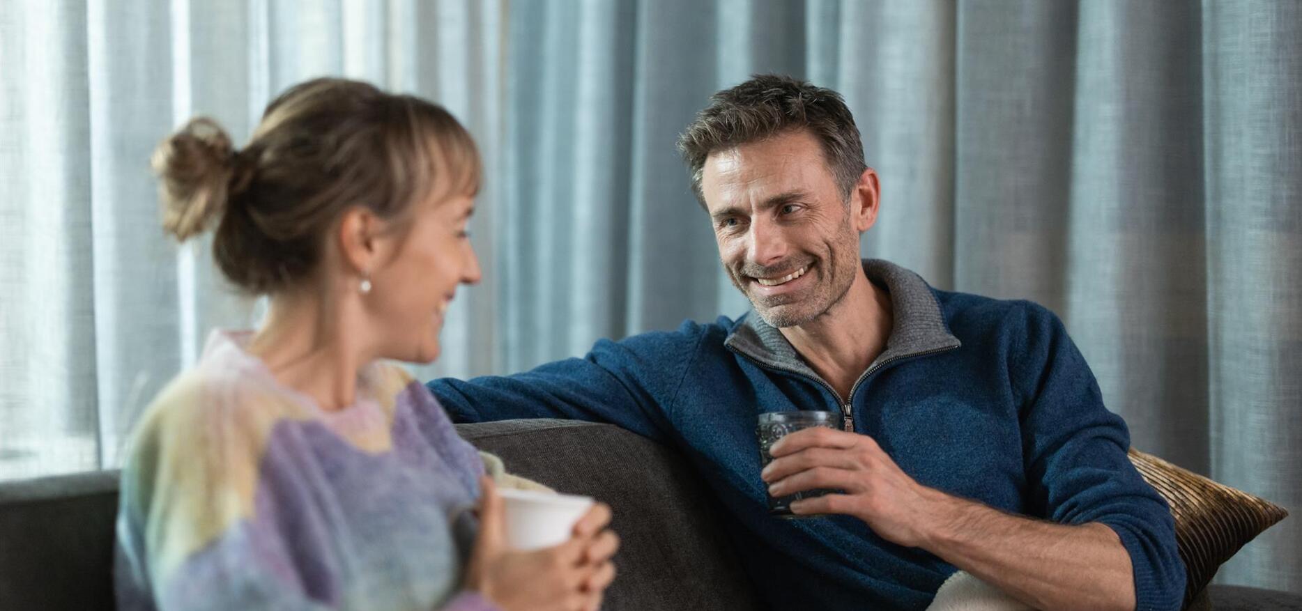 Un uomo e una donna bevono una tazza di tè su una sdraio